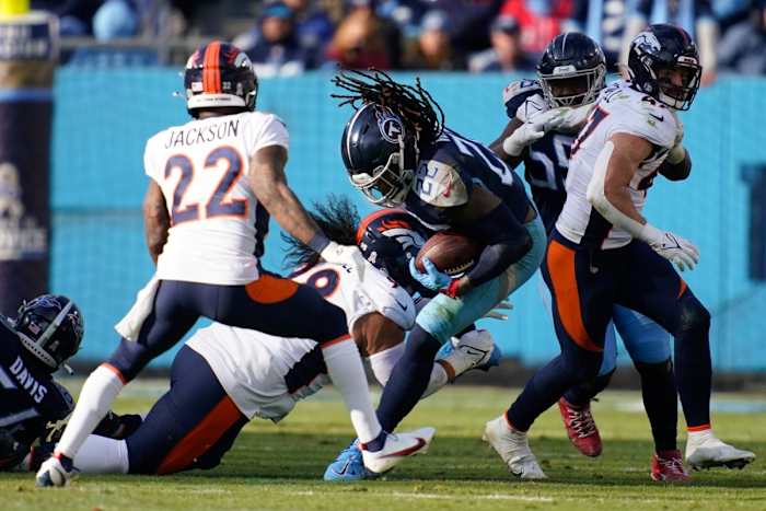 Tennessee Titans running back Derrick Henry (22) gets tackled by Denver Broncos defensive tackle Mike Purcell (98) during the third quarter at Nissan Stadium.
